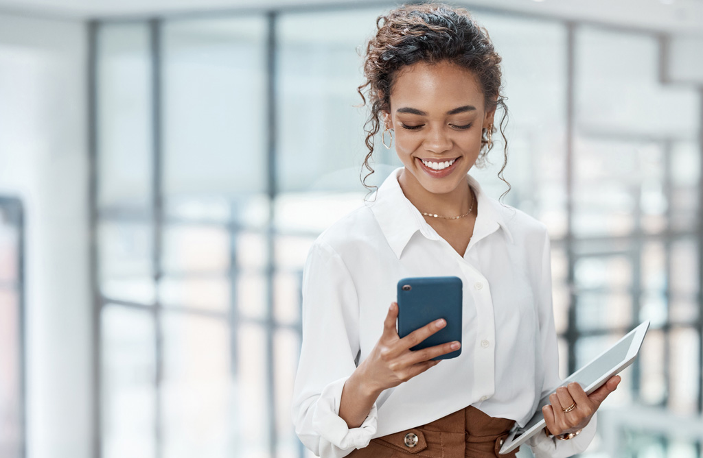 Lady Smiling Reading Message on her Phone in Office